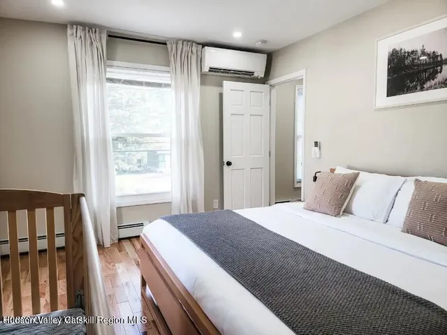 a bedroom with a bed a chair and next to a window