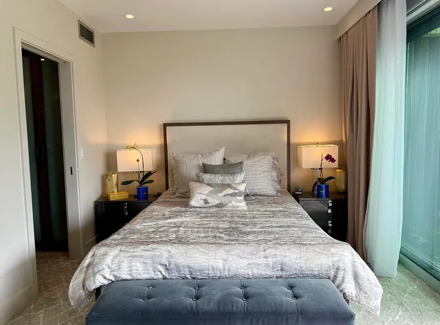 a bed sitting in a bedroom next to a lamp