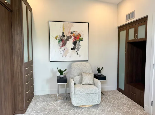 a living room with furniture and a painting on the wall