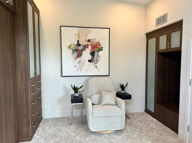 a living room with furniture and a painting on the wall