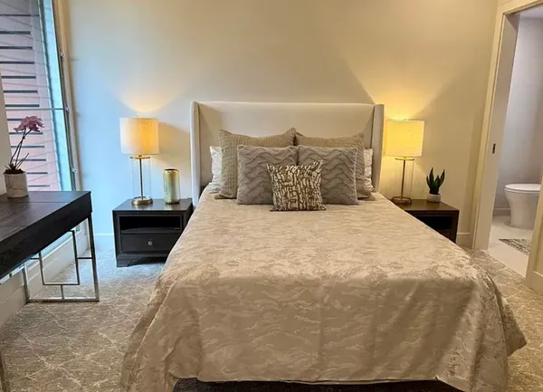 a large bed sitting in a bedroom next to a window