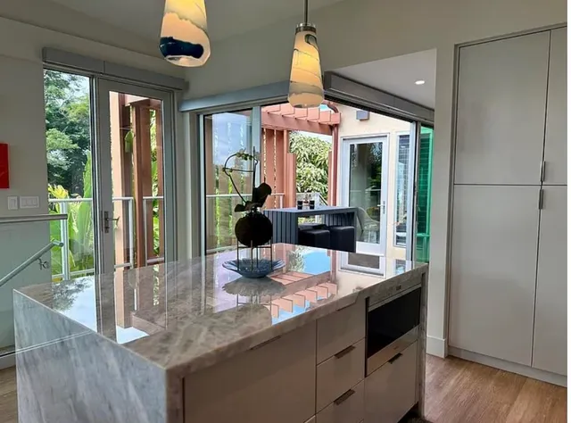 a kitchen view with granite countertop a stove and a view of living room