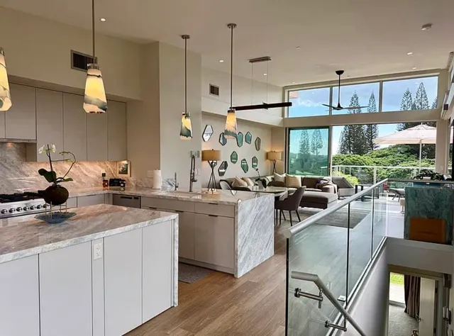 a kitchen with stainless steel appliances a stove a sink a refrigerator and chairs
