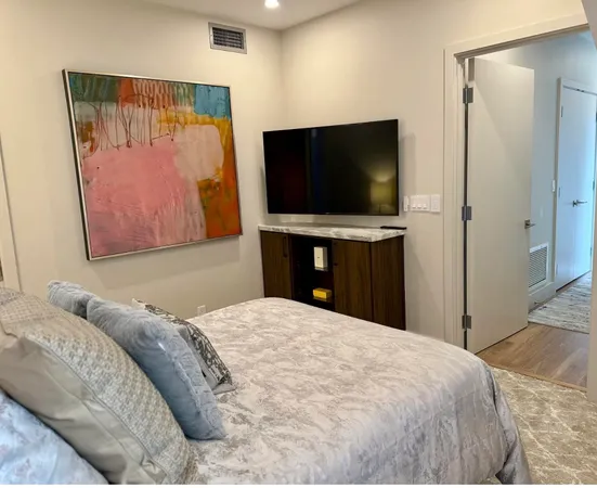 a bedroom with a large bed and a flat screen tv