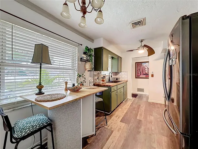 a kitchen with stainless steel appliances granite countertop a stove a sink dishwasher and a refrigerator with wooden floor