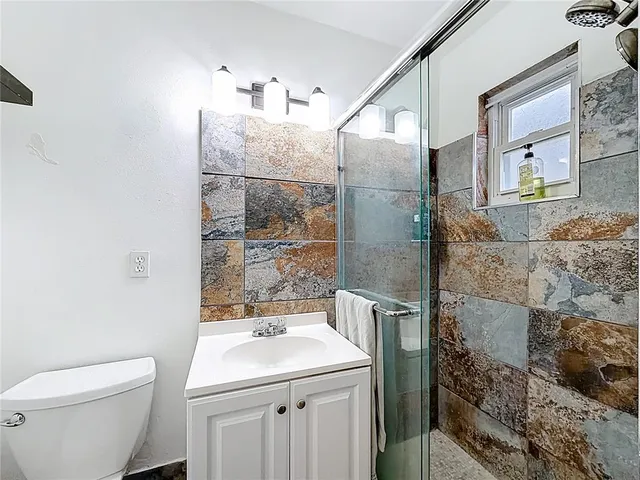 a bathroom with a sink toilet and shower