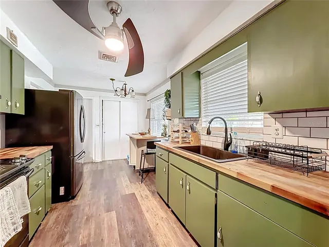 a kitchen with sink a refrigerator and wooden floor