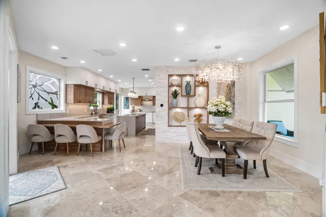 a kitchen with stainless steel appliances kitchen island granite countertop a refrigerator and a sink
