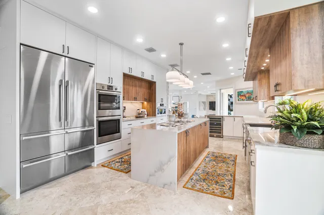 a kitchen with granite countertop a refrigerator sink and cabinets