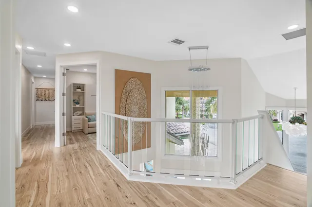 a view of a hallway with wooden floor and front door