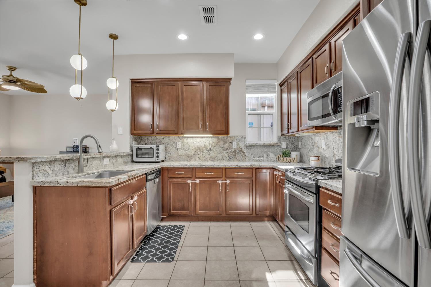 62 South Rio Rapido Drive Tracy, CA 95391 - Photo 16 of 40 a kitchen with stainless steel appliances granite countertop a sink and stove