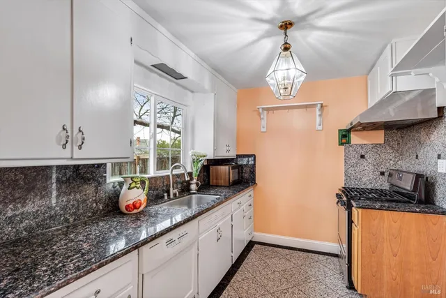 a very nice looking kitchen with granite countertop a sink a window and stainless steel appliances