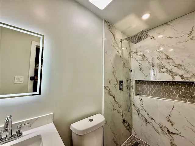 a white toilet sitting next to a bathroom sink