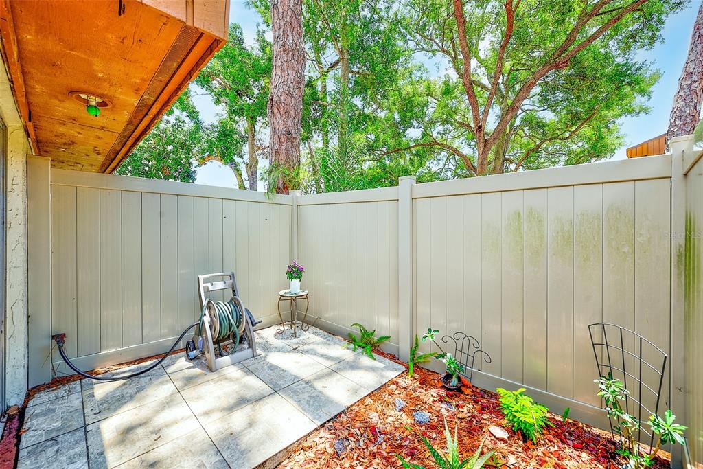 2064 Sunset Point Road, Unit 73 Clearwater, FL 33765 - Photo 36 of 58 a view of chair and table in backyard