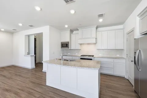 a kitchen with stainless steel appliances granite countertop a stove a sink and a refrigerator