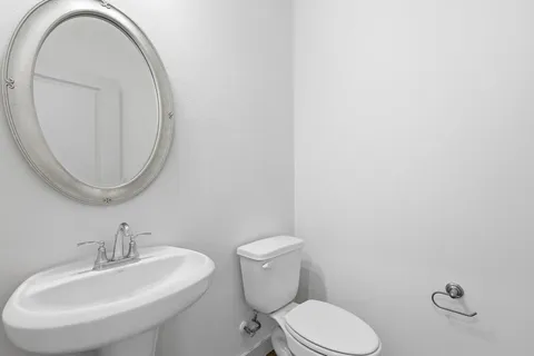 a bathroom with a toilet a sink and a mirror