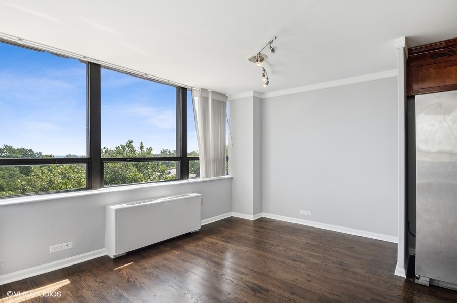 5701 North Sheridan Road, Unit 5T Chicago, IL 60660 - Photo 14 of 27 an empty room with wooden floor and windows