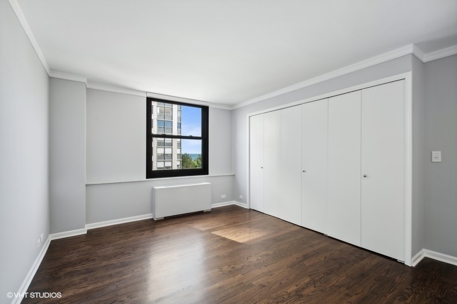 5701 North Sheridan Road, Unit 5T Chicago, IL 60660 - Photo 17 of 27 an empty room with wooden floor and windows