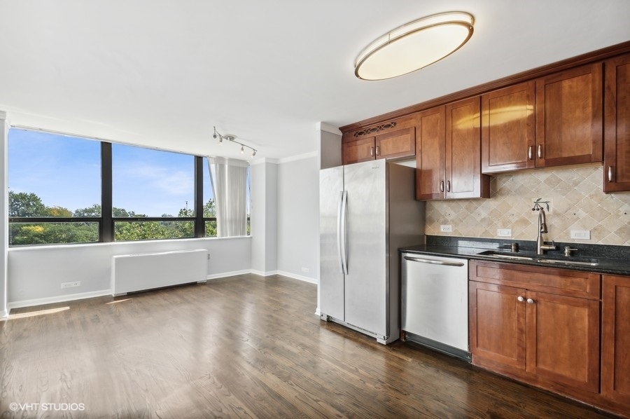 5701 North Sheridan Road, Unit 5T Chicago, IL 60660 - Photo 9 of 27 a kitchen with stainless steel appliances a refrigerator sink and cabinets