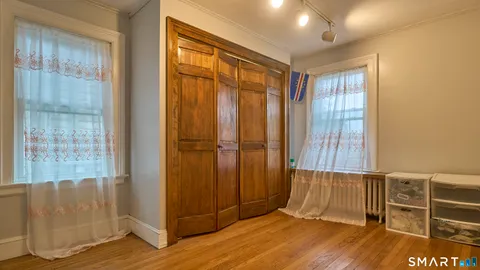 an empty room with wooden floor and closet