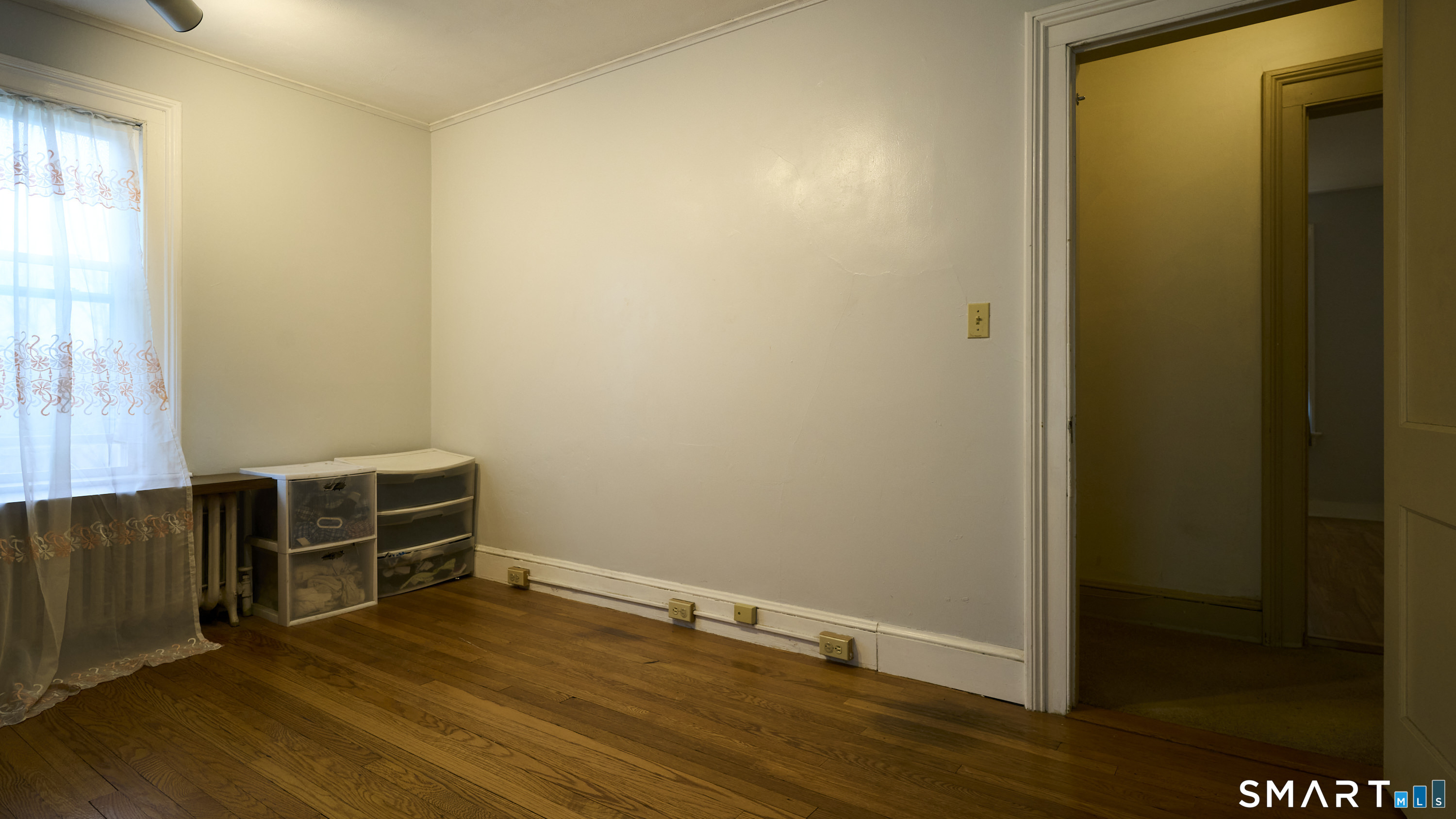 181 Buckingham Street Waterbury, CT 06710 - Photo 27 of 38 a view of an empty room with wooden floor and a window