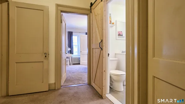 a view of a bathroom with wooden floor and a window