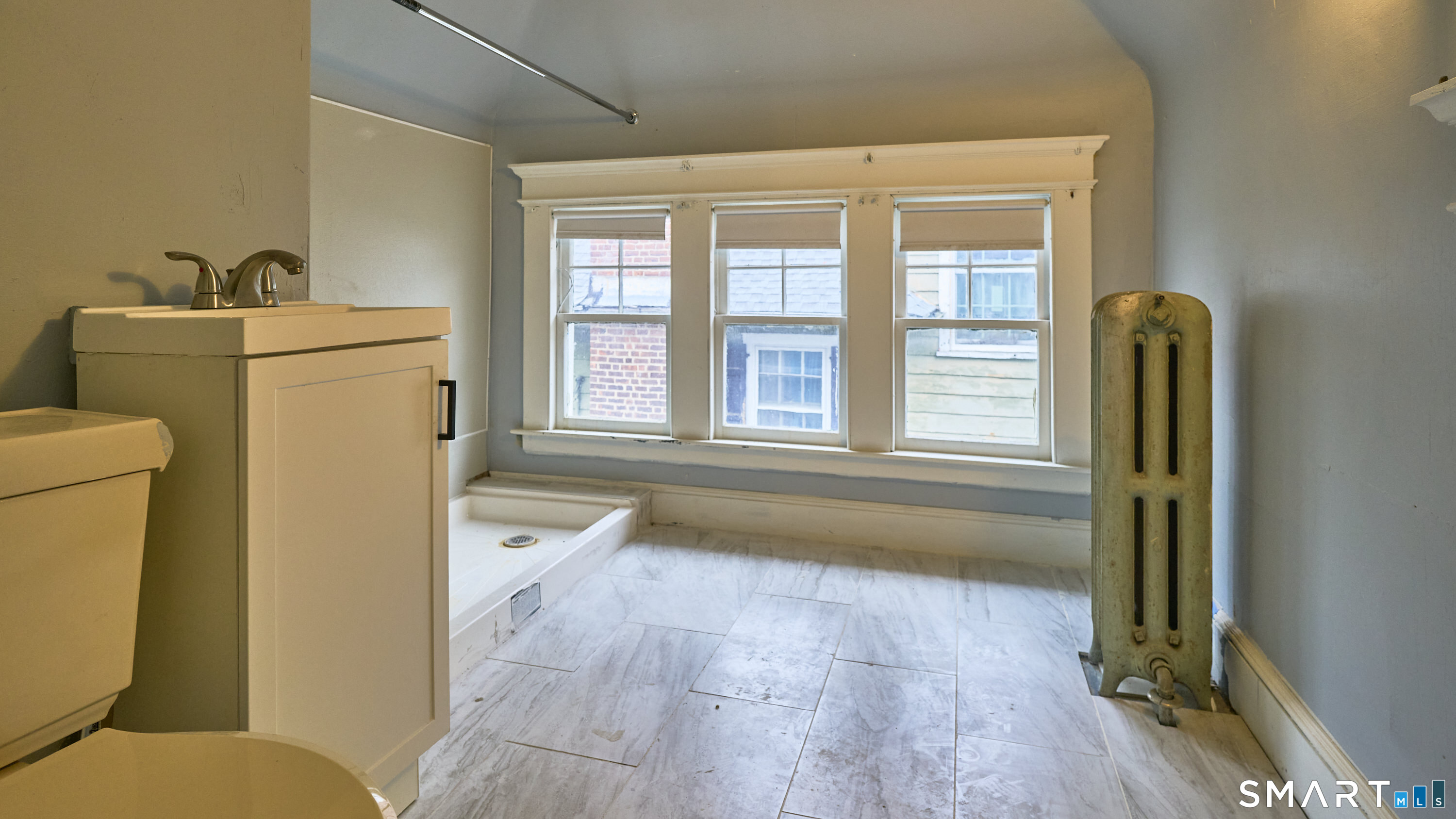 181 Buckingham Street Waterbury, CT 06710 - Photo 35 of 38 a spacious bathroom with a granite countertop toilet a sink and a large mirror