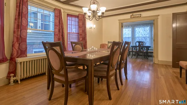a view of a a dining room with furniture window and wooden floor