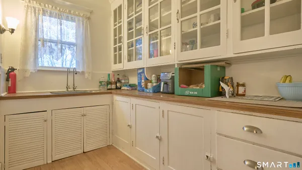 a kitchen with white cabinets and sink