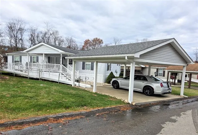 a car parked in front of a house with a yard