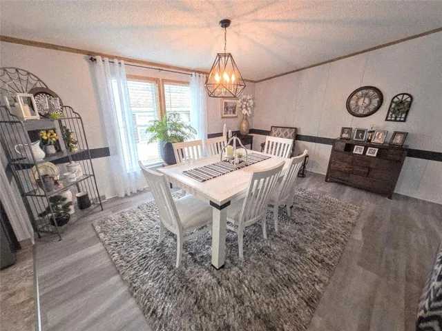 a dining room with furniture a chandelier and wooden floor