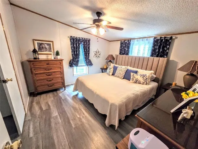 a bedroom with a bed a dresser and potted plants on the dresser