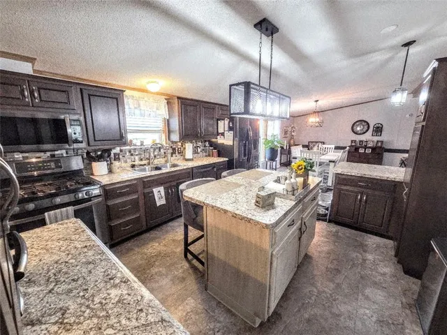 a kitchen with a stove a refrigerator and a microwave