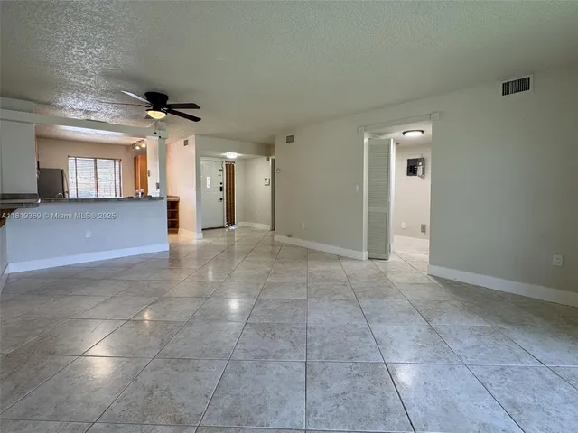 a view of a livingroom with an empty space and a window