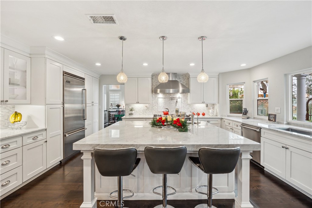 a kitchen with a dining table chairs and white cabinets