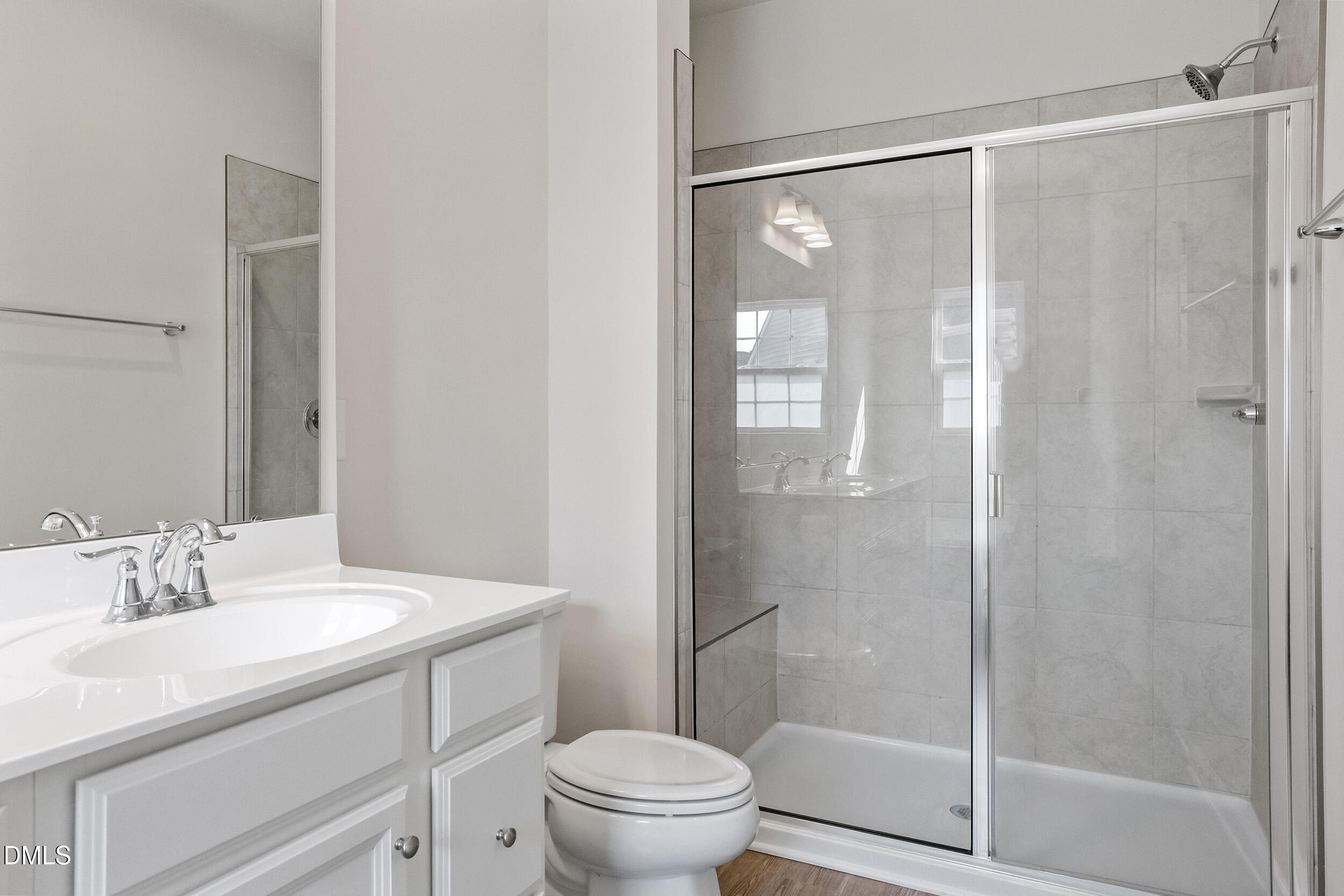 1124 Platform Drive Apex, NC 27502 - Photo 25 of 34 a bathroom with a shower sink vanity mirror and toilet