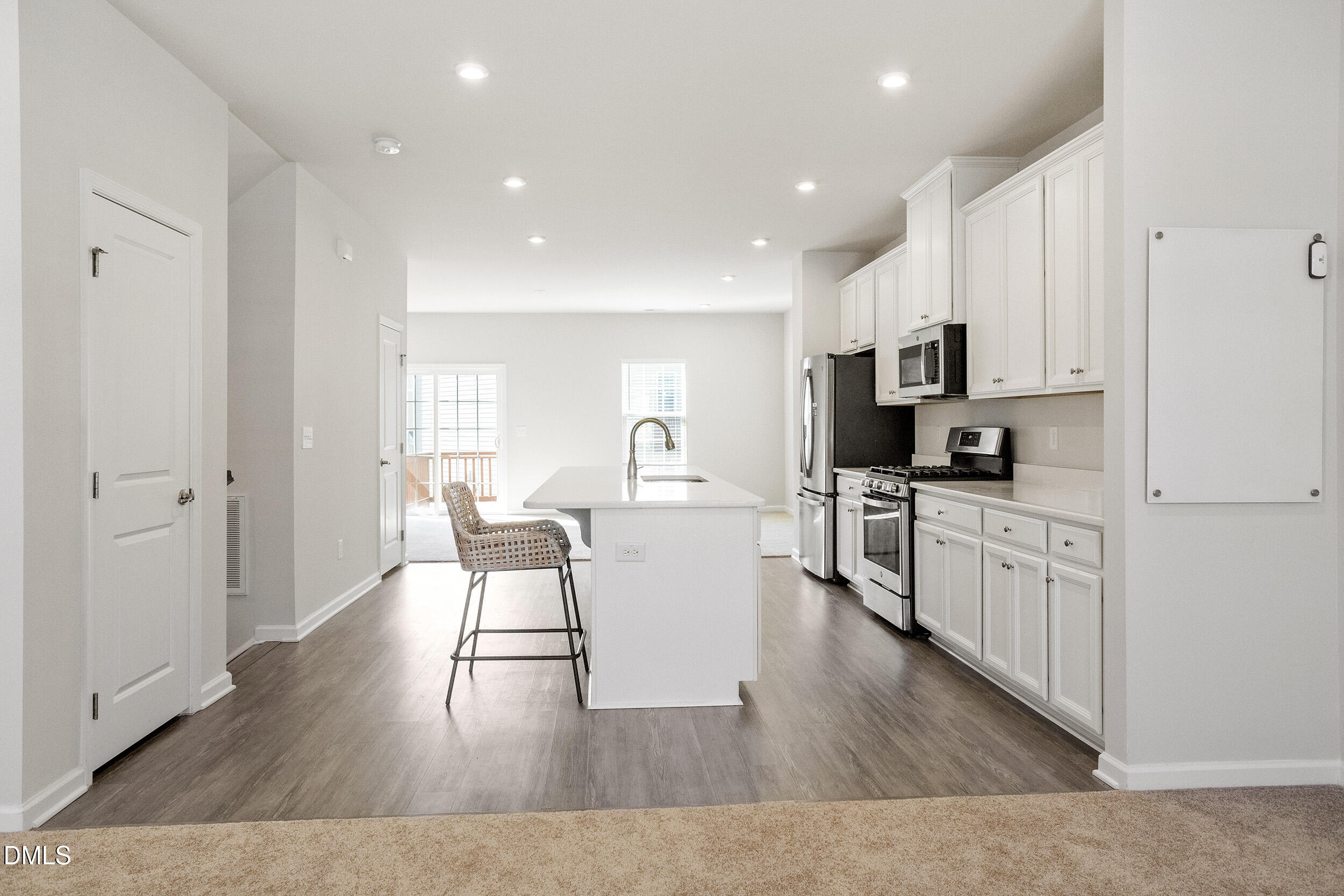 1124 Platform Drive Apex, NC 27502 - Photo 7 of 34 a kitchen with white cabinets and wooden floor