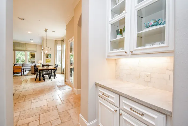 a view of a hallway with dining area and chandelier