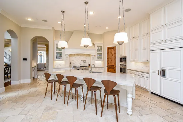 a kitchen with cabinets and chairs