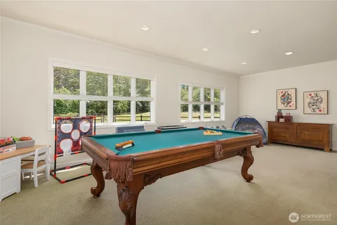 a room with furniture pool table and windows