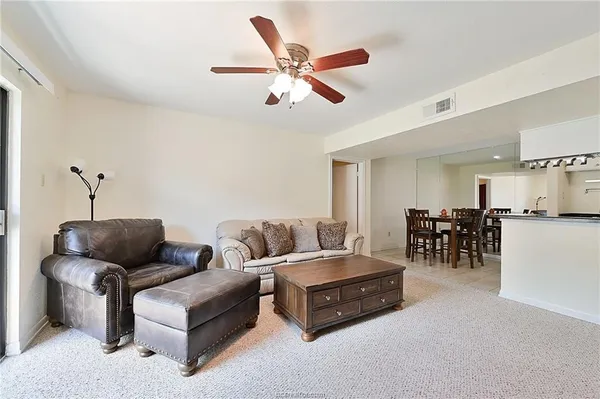 a living room with furniture and kitchen