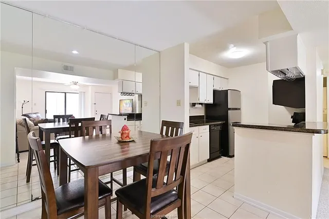 a dining room with stainless steel appliances furniture a dining table and chairs