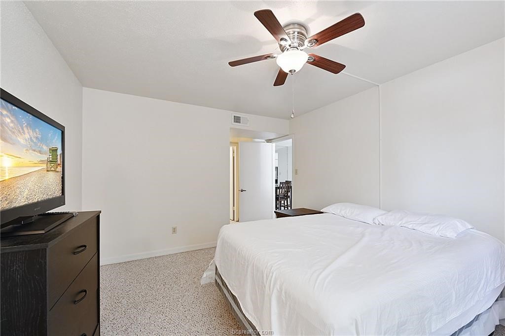 904 University Oaks Boulevard, Unit 155 College Station, TX 77840 - Photo 7 of 11 a bedroom with a bed and a flat screen tv