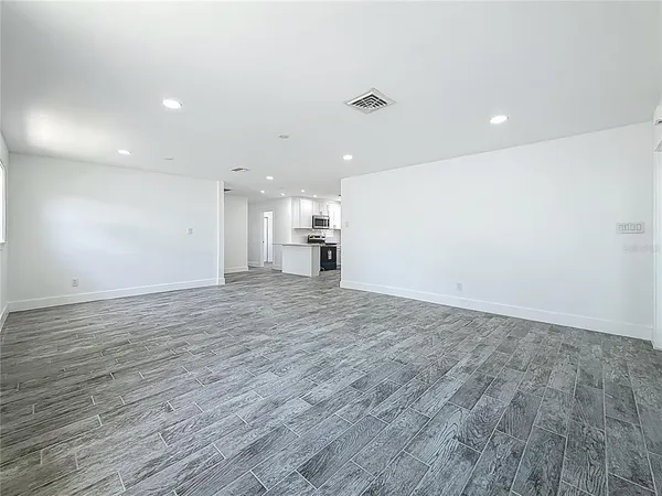 a view of empty room with wooden floor