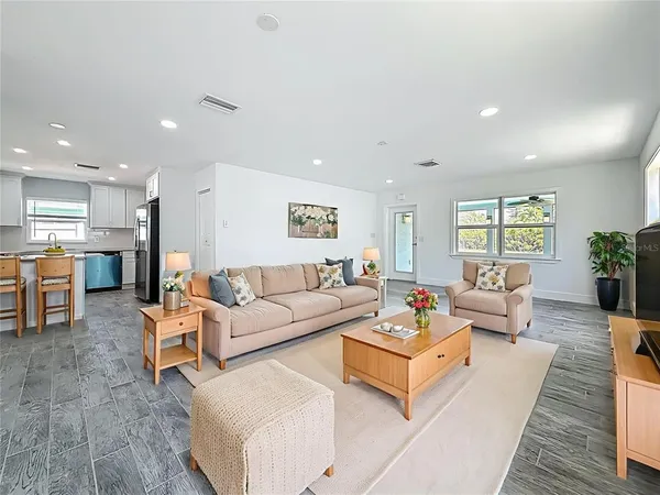 a living room with furniture and kitchen view
