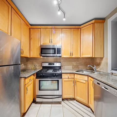 a kitchen with kitchen island granite countertop a stove top oven microwave and refrigerator