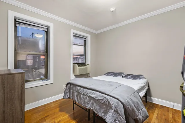 a bedroom with a bed and wooden floor