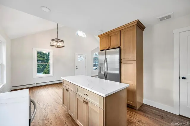 a view of empty room with wooden floor and windows