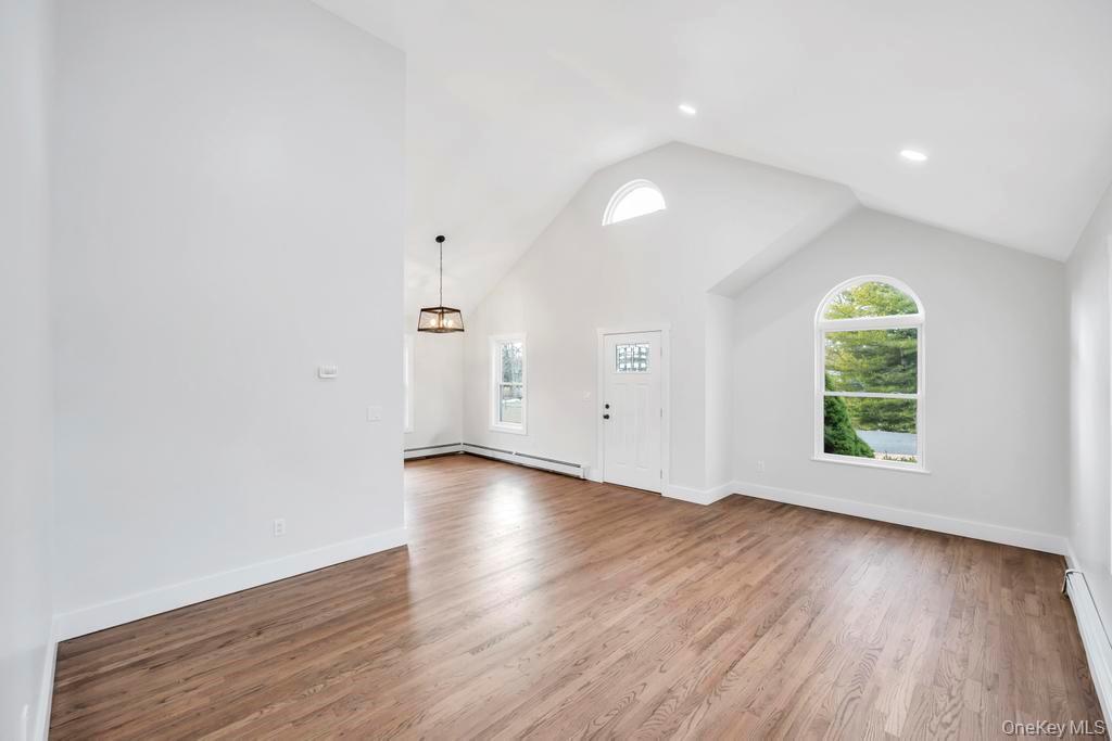 160 Oak Street Mattituck, NY 11952 - Photo 11 of 29 an empty room with wooden floor and window