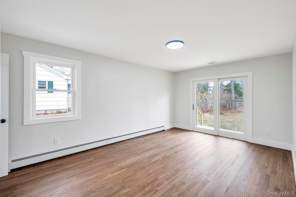 160 Oak Street Mattituck, NY 11952 - Photo 12 of 29 an empty room with wooden floor and windows